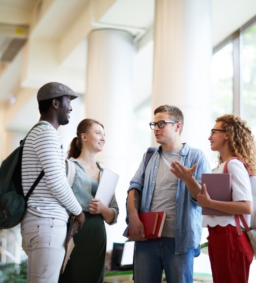 Group of college students gathering and talking together on campus