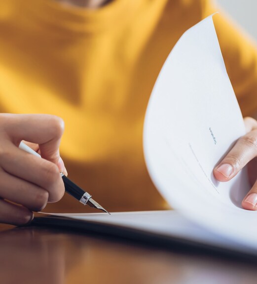 Close up view of a person reviewing disclosures on sheets of paper