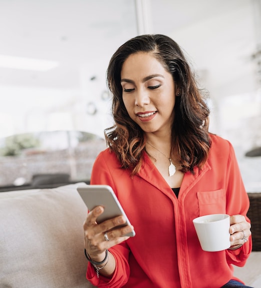 Woman checking the news on her phone while drinking coffee