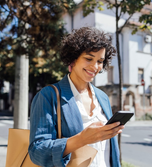 A smiling woman looking down at her phone