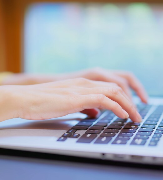 Close up view of hands typing at a laptop computer