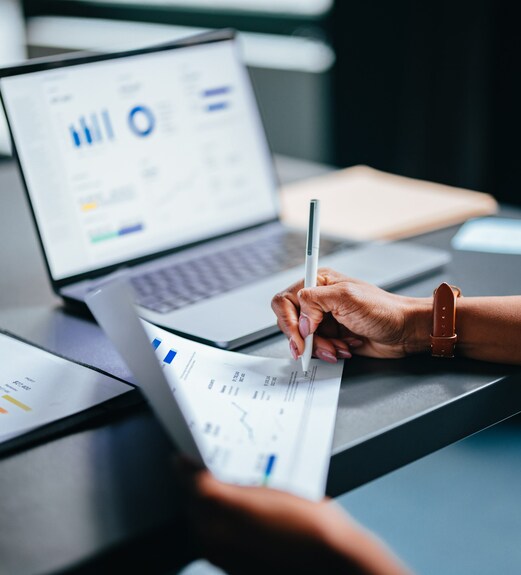 Person analyzing reports on their laptop