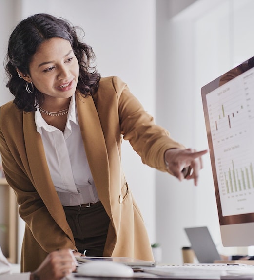 Young woman pointing to financial services reports on a computer