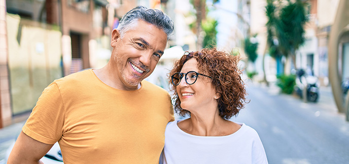 Couple walking down a sunny street together
