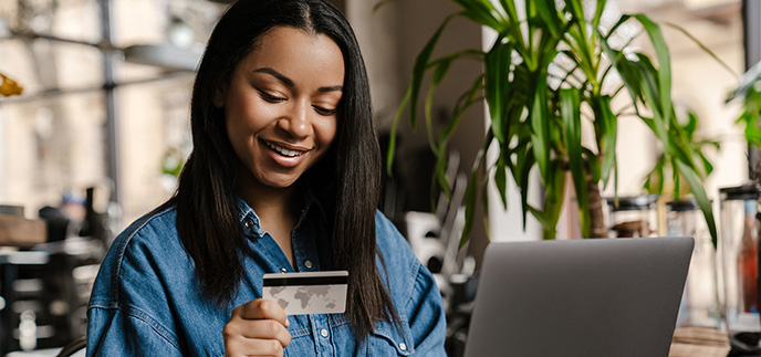 Woman checking her credit card number making an online purchase