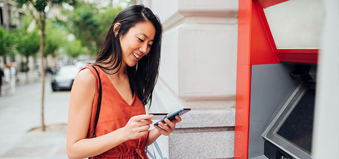 Woman checking her account at an ATM outside
