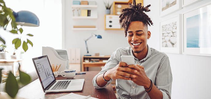 Young man smiling checking his credit score on his phone