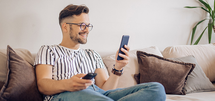 Young man checking his bank account on his phone at home
