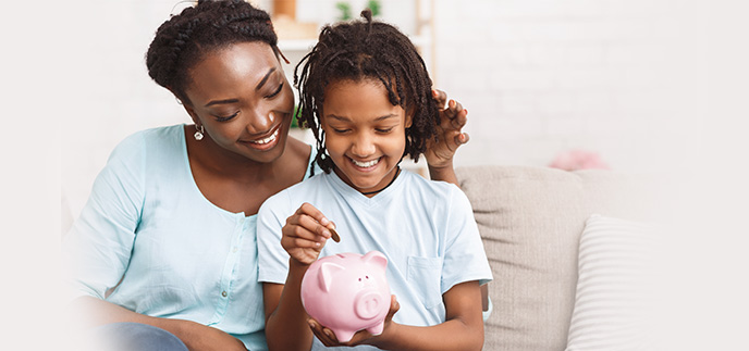 Mother and son putting coins into a piggy bank